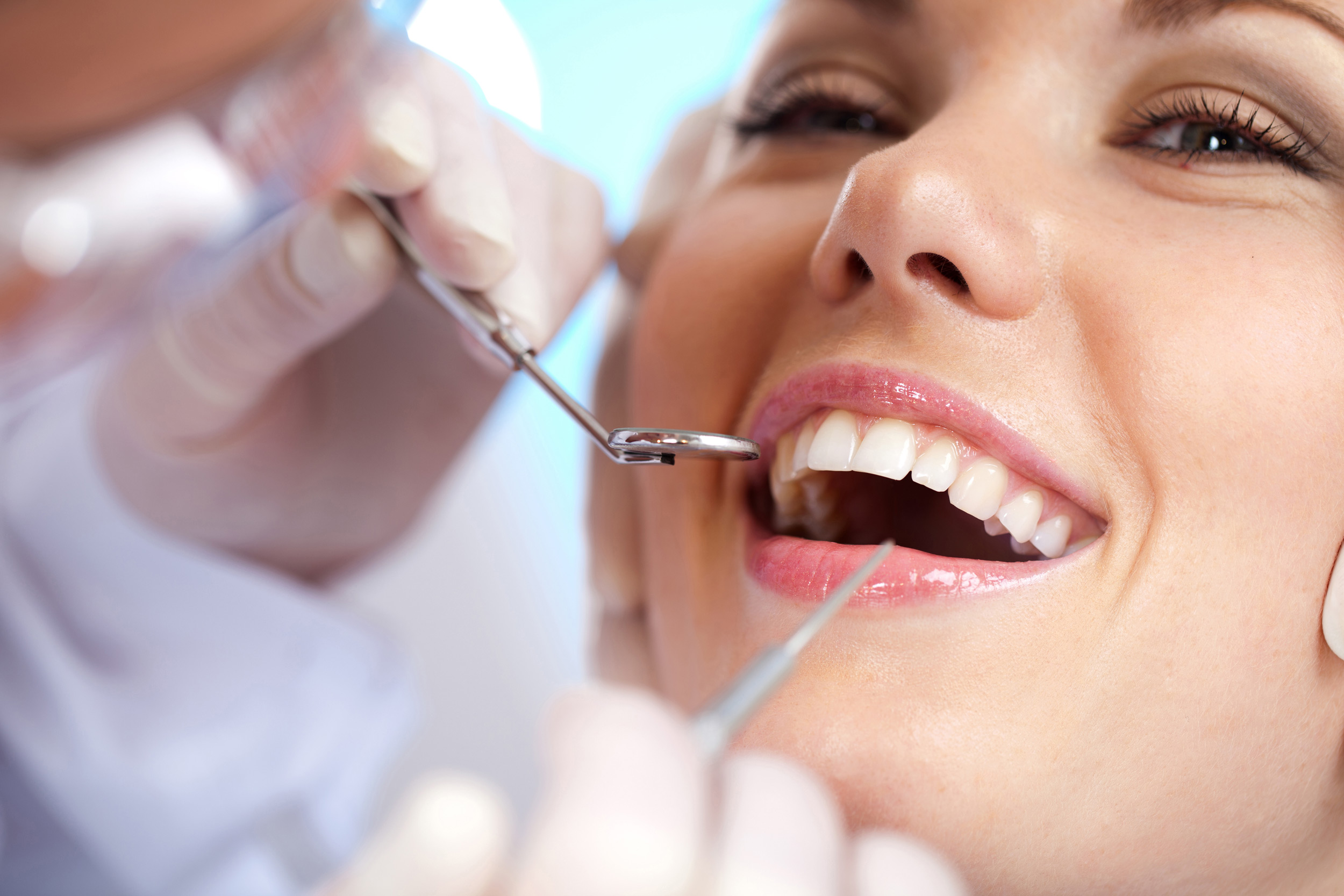 Dentista realizando procedimento e cliente sorrindo