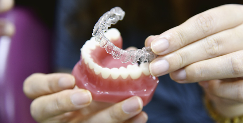 demonstração de como funciona o tratamento com Invisalign em um modelo dental