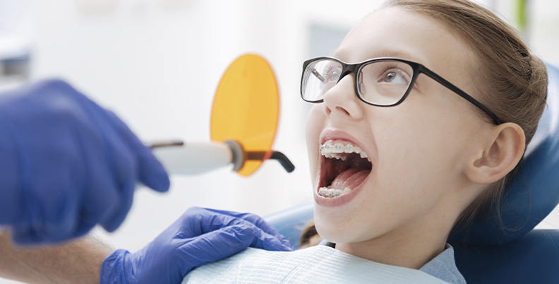 criança usando aparelho em uma consulta no dentista
