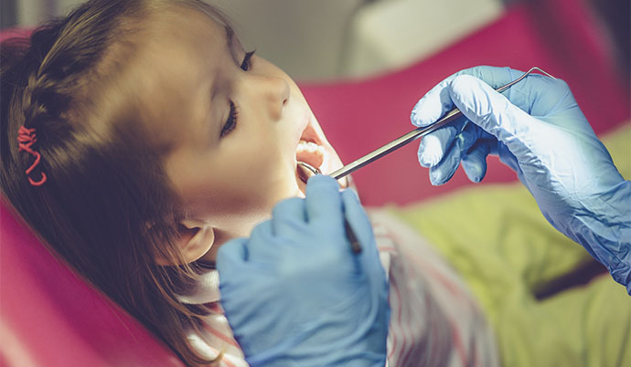 Menina pequena em uma consulta ao dentista.