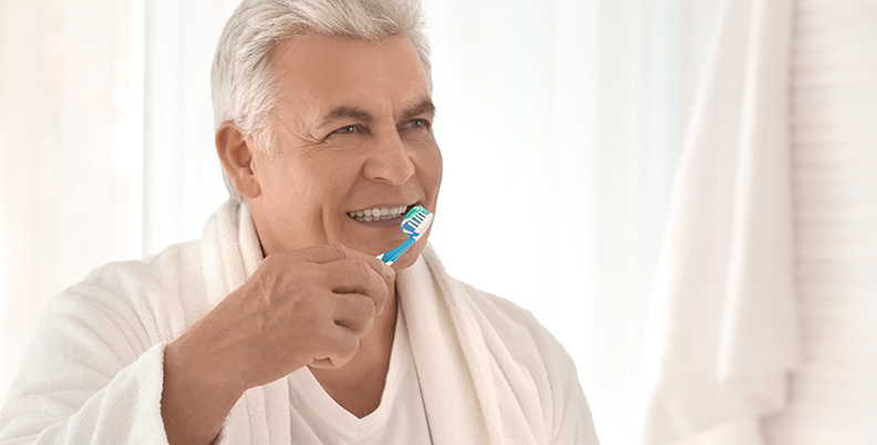 homem idoso escovando os dentes