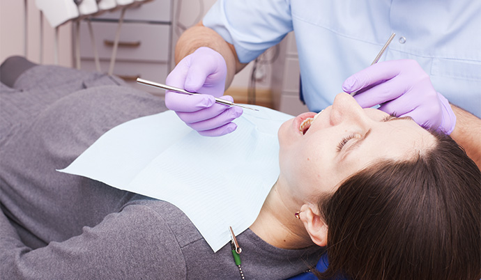 mulher no dentista fazendo tratamento para dentes sensíveis